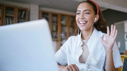 Woman waving at laptop screen