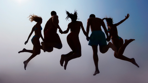 Young People jumping together and holding hands