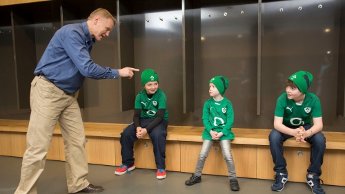 Joe Schmidt speaking to three children in Irish dressing room