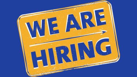 We are hiring graphic in blue lettering on a yellow sign