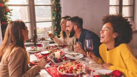 5 people having Christmas Dinner and Laughing